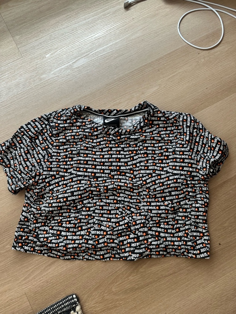 Nike Women’s Black Cropped Tee with White and Orange All-Over 'Just Do It' Print
